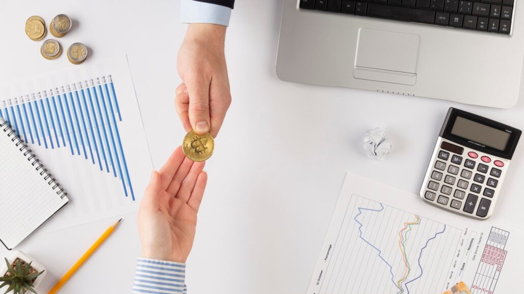 Hand passes bitcoin on the background of a table in the office